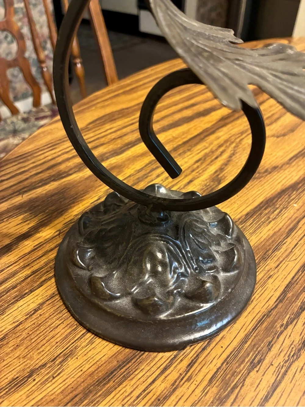 vintage-style brown cast iron pillar candle holder features an ornate leaf